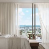 bedroom with large bed tv and sliding doors to a balcony